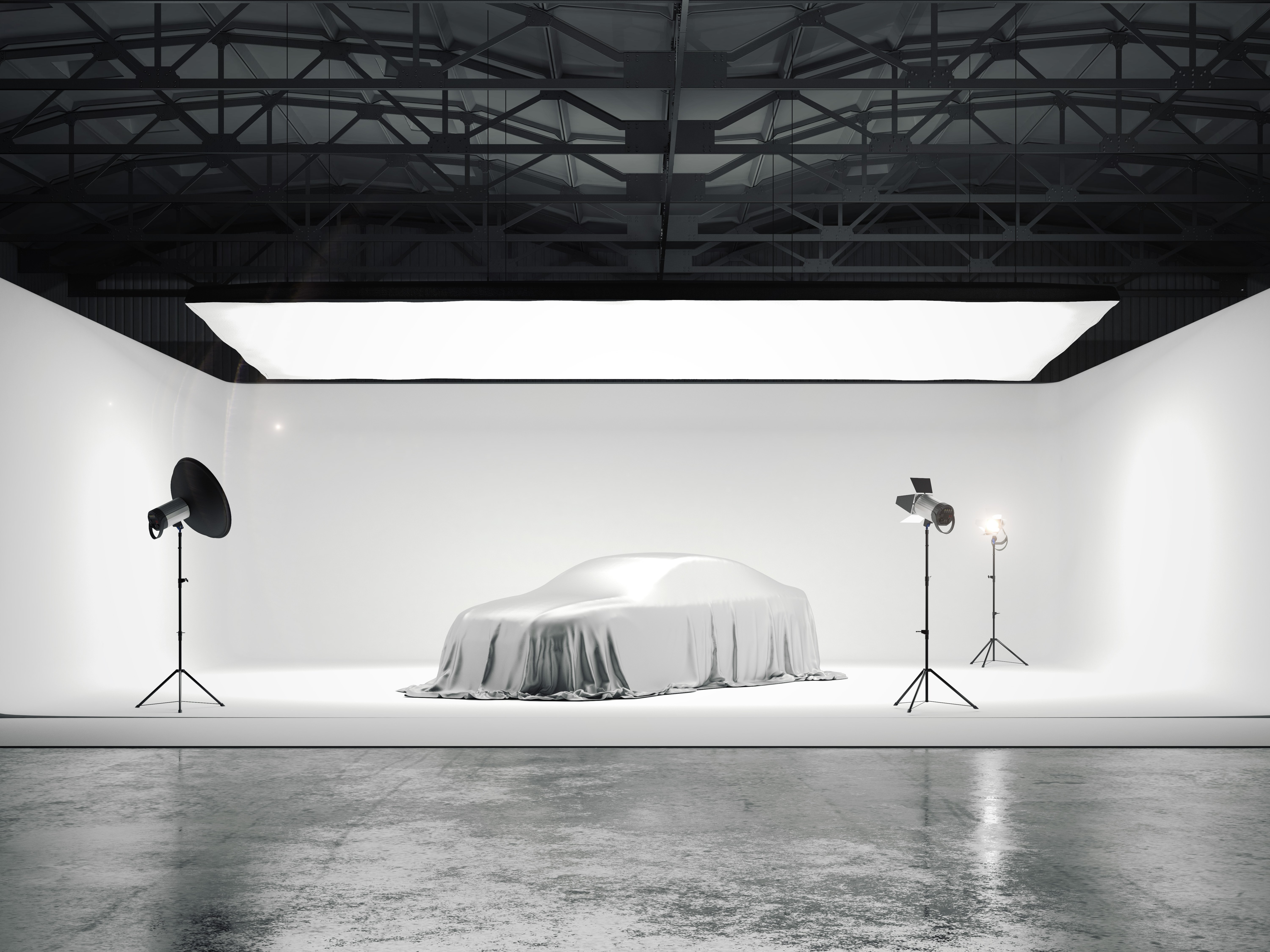 Großes Fotostudio mit einem Auto und mehreren Lichtquellen